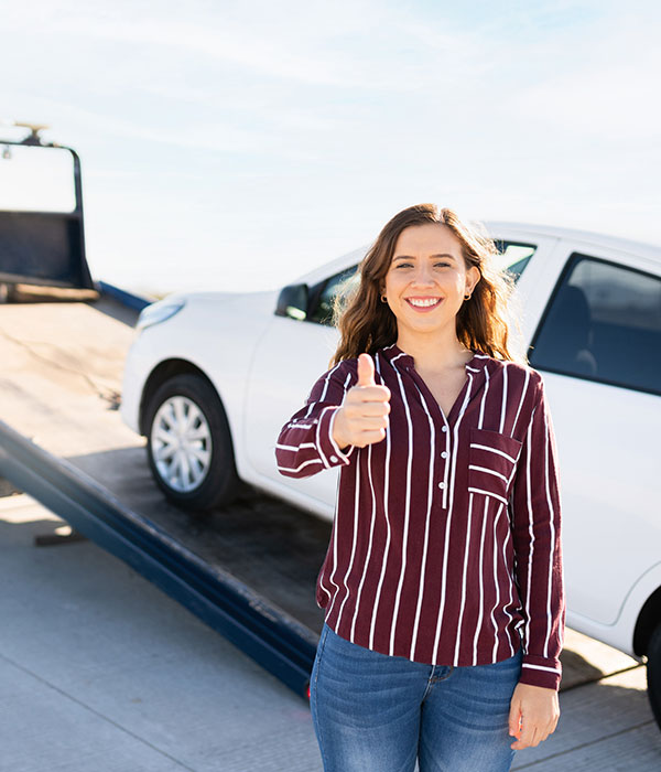 Customer with thumbs up getting white vehicle towed at Top Notch Recovery